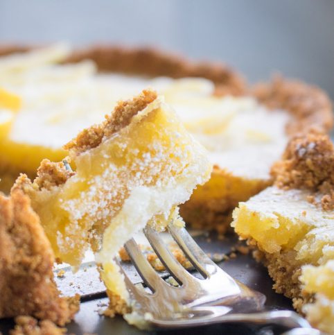 Lemon tart with pistachio cardamom crust on a fork