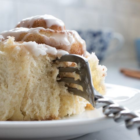 Glazed cinnamon rolls upclose with leading fork