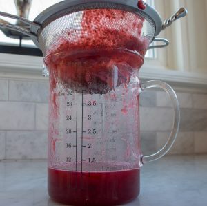 Raspberry sauce being strained