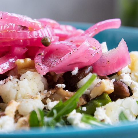 Pickled red onions on top of a salad