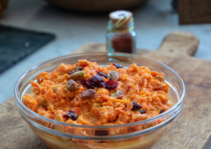 Carrot Halwa, cooked and garnished with dried cranberries and pistachios